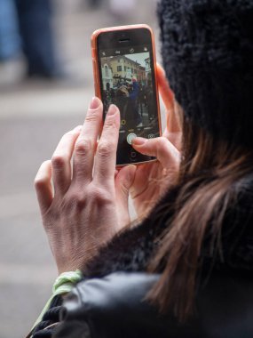 Cremona, İtalya - 9 Aralık 2022 Yetişkinler Bir sokak festivalini kameralı telefonlarla çekiyorlar.