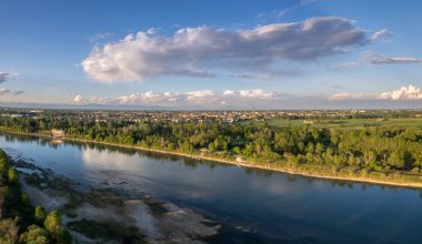 Cremona ve Po nehrinin güneş batmadan önceki havadan çekilmiş görüntüleri. Köprü, sahil, park. Lombardy, İtalya