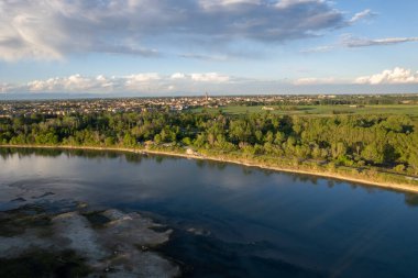 Cremona ve Po nehrinin güneş batmadan önceki havadan çekilmiş görüntüleri. Köprü, sahil, park. Lombardy, İtalya