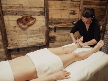 Masör kaplıca salonunda yağ ile ayak masajı yapıyor. Spa prosedürleri. Rahatlatıcı, sağlıklı ayak masajı. Vücut bakımı konsepti. Kadın ayak terapisi..
