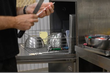 Profesyonel mutfak aletleri ve aletleri temizleyen personel, güvenli hijyen konsepti