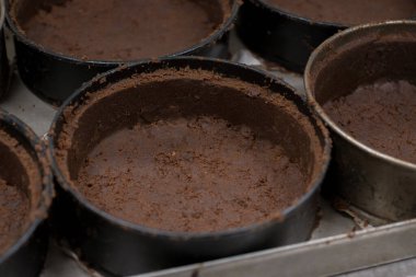 Pasta şefi, profesyonel mutfakta tuzlu karamel peynirli kek için grup çikolatası hazırlıyor ve pişiriyor.