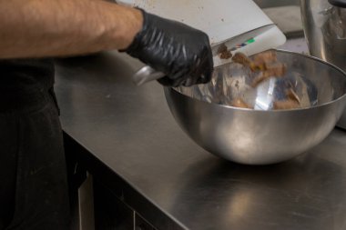 Cheesecake hazırlamak için çikolatalı şekerleme kesen şef. Yakın çekim, yemek servisi yapan profesyonel mutfak.