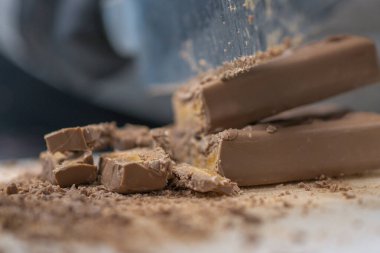 Cheesecake hazırlamak için çikolatalı şekerleme kesen şef. Yakın çekim, yemek servisi yapan profesyonel mutfak.