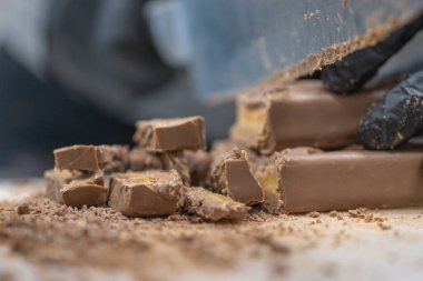 Cheesecake hazırlamak için çikolatalı şekerleme kesen şef. Yakın çekim, yemek servisi yapan profesyonel mutfak.