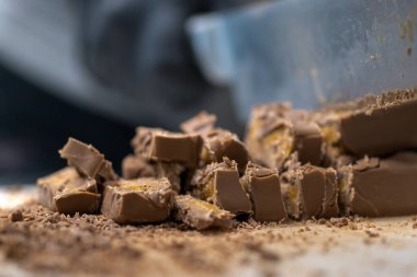 Cheesecake hazırlamak için çikolatalı şekerleme kesen şef. Yakın çekim, yemek servisi yapan profesyonel mutfak.