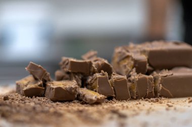 Cheesecake hazırlamak için çikolatalı şekerleme kesen şef. Yakın çekim, yemek servisi yapan profesyonel mutfak.