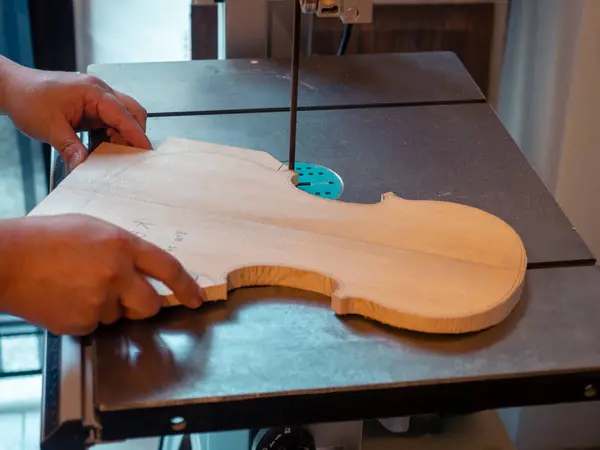 violin maker sawing a classical italian violin top plate