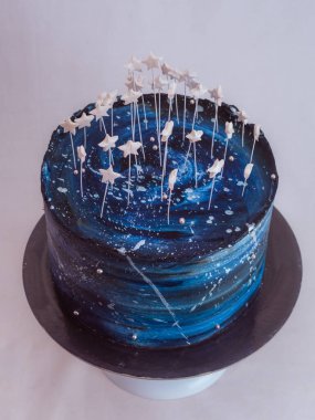 Doğum günü için buzlu kek, yıldızlı bir gökyüzü, mavi bir palet ve stüdyoda izole edilmiş yıldızları temsil ediyor.