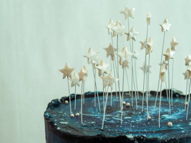 Doğum günü için buzlu kek, yıldızlı bir gökyüzü, mavi bir palet ve stüdyoda izole edilmiş yıldızları temsil ediyor.