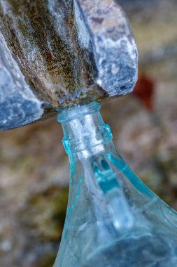 Bir bardak yeniden kullanılabilir. 5 litre. Tedavi edilmemiş nehir mineral suyunu insan tüketimi için dağdaki kaynaktan topluyor.