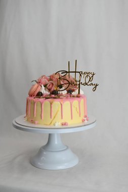 Taze krema damlayan pembe vanilyalı pasta gerçek güller ve üzerinde altın işareti olan badem kurabiyesi.