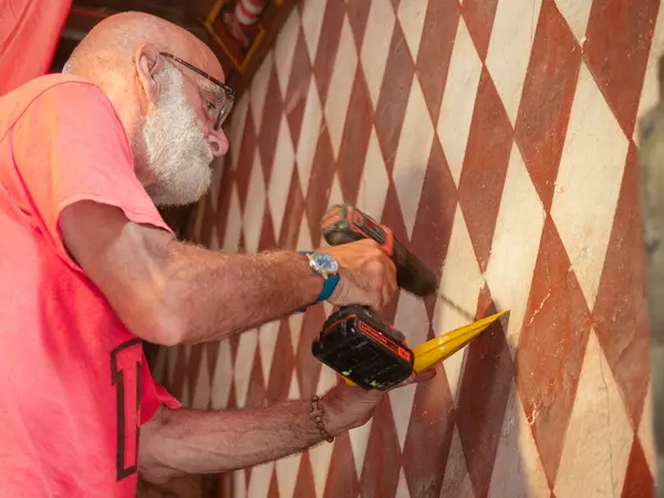 senior caucasian bearded bold fit man working in home restoration diy