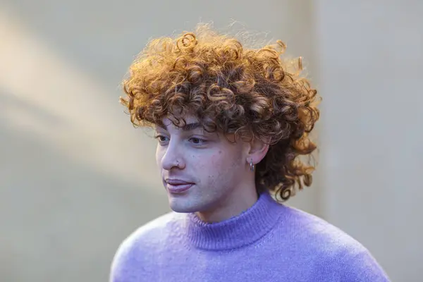 portrait of a young red haired caucasian curly man using v polo neck outdoor winter over solid background beige wall
