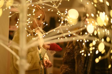 Kadınlar kış mevsiminde bebek bezi ve giysi alışverişi yaparlar.