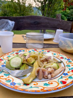 Güzel bir el yapımı ve el boyalı İtalyan yemeği bir demet ızgara karides ve kabak ile birlikte terasta yemeye hazır.