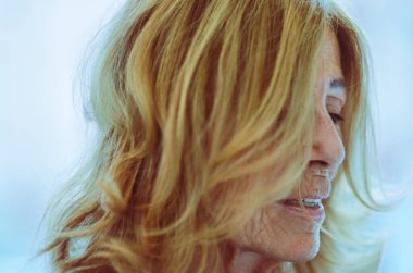 Beyaz bir arkaplan üzerinden sarışın, beyaz, yaşlı bir kadının portresini kapat.