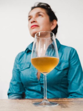 Sıcak bir restoranda beyaz şarabı değerlendiren kadın şarap garsonu. Zevk ve uzmanlık yayıyor. Kutlamalar ya da aperatifler için mükemmel. Şarap sevenlerin şerefine..