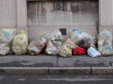 Cremona, İtalya - 27 Mayıs 2024 taşan plastik sarı çöp torbaları aşırı atık ve kirliliği vurguluyor, geri dönüşüm ve sürdürülebilirliği vurguluyor
