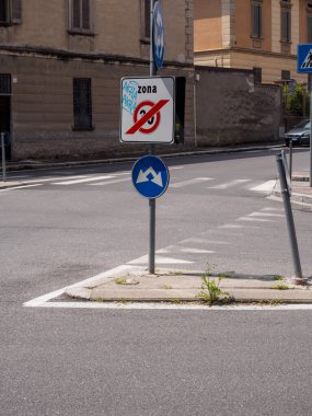 Cremona, İtalya - 27 Mayıs 2024 Sprey boyayla boyanmış bir park levhası gösteriyor, bu da arka planda yaya geçidi ve kaldırımı olan iki yönlü bir trafik yolunu gösteriyor.