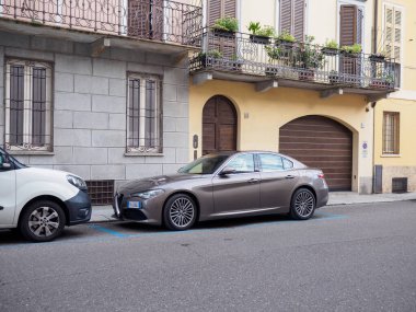 Cremona, İtalya - 27 Mayıs 2024 Alfa Romeo Giulia Lüks sedan metalik kahverengi sedan Avrupa caddesinde park halinde sofistike ve stil yayıyor, şehir planıyla mükemmel bir şekilde harmanlanıyor.
