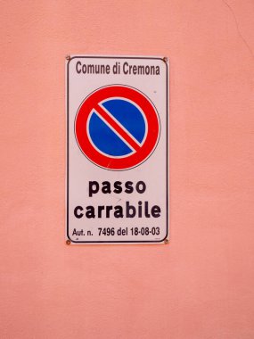 Cremona, İtalya - 27 Mayıs 2024 Sürücü ve sürücülere kurallara uymalarını hatırlatan, şeftali rengi bir duvarda park yasağı işareti sergileniyor