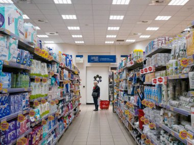 Cremona, İtalya - 27 Mayıs 2024 Yaşlı Kadın yoğun bir süpermarketten alışveriş yapıyor ve çok çeşitli ürünler seçiyor