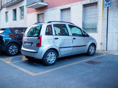 Cremona, İtalya - 27 Mayıs 2024 Arka kapısında bir göçük olan gümüş araba bir otoparkta park halinde. Araba mavi engelli park yerinin yanına park edilmiş..
