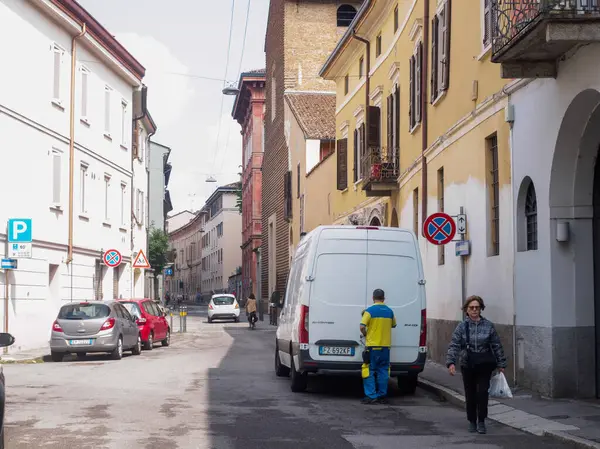 Cremona, İtalya - 27 Mayıs 2024 Poste Italiane Pack Teslimat sürücüsü tarihi bir İtalyan kasabasına teslimat yapmaya hazırlanırken, minibüsüyle caddeyi kapatıyor.