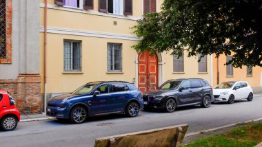 Cremona, İtalya - Haziran 2024 Antika bir İtalyan köyünde dar bir caddenin kenarına park edilmiş araçlar