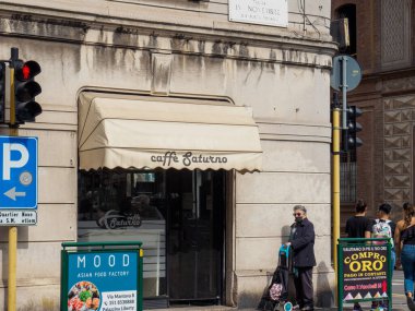 Cremona, İtalya - 10 Haziran 2024 Koruyucu yüz maskesi takan kadın İtalya 'da bir kafenin önündeki kaldırımda duruyor.