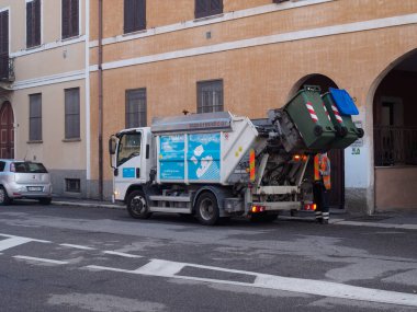 Cremona, İtalya - 10 Haziran 2024 Çöp toplayıcısı, konut alanında çalışıyor, çöp kamyonuyla atık topluyor