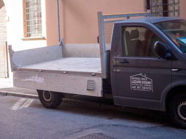 Cremona, İtalya - 10 Haziran 2024 Boş kamyonet bir binanın önünde park halinde, bir sonraki teslimatı için hazır.