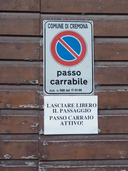 Cremona, İtalya - 10 Haziran 2024 Passo Carrabile tabelası İtalya 'da ahşap bir kapıda sergilenmiş.