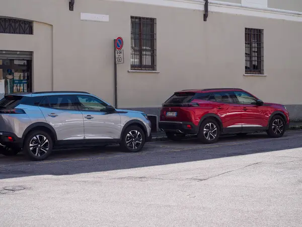 stock image Cremona, Italy - June 10th 2024 Two contemporary identical Peugeot suvs are parked in a narrow alley in a historic italian village