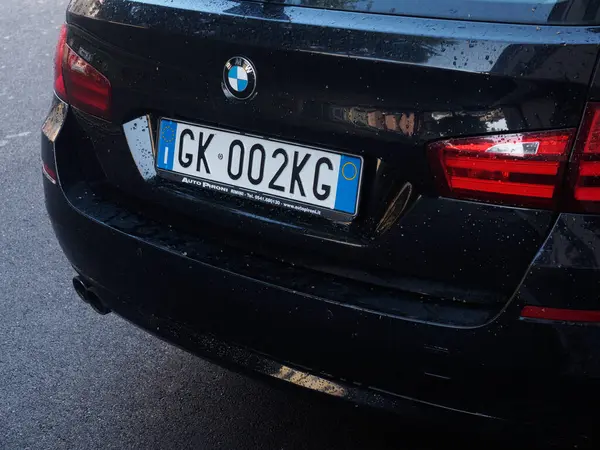 Cremona, İtalya - 10 Haziran 2024 Bulutlu bir günde caddeye parketmiş siyah bir steyşın arabanın arka görüntüsü, araba gövdesinde yağmur damlaları