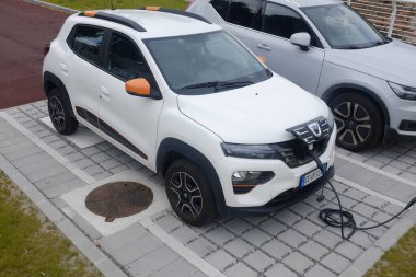 Cremona, İtalya - 15 Haziran 2024 Dacia Electric SUv beyaz arabalı bir kamu şarj istasyonunda pilini şarj ediyor