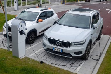 Cremona, İtalya - 15 Haziran 2024 Dacia ve Volvo elektrikli araçları kentsel şarj istasyonunda şarj ediliyor