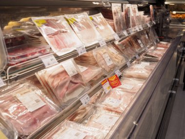 Cremona, İtalya 19 Temmuz 2024 Süpermarketteki soğutucunun içinde buzun üzerinde duran çeşitli paketlenmiş salamlar.