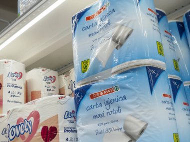 Cremona, İtalya 19 Temmuz 2024 Bir süpermarket müşterisi raftan bir paket tuvalet kağıdı seçiyor