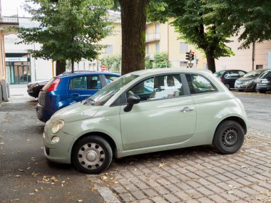 Cremona, İtalya 19 Temmuz 2024 İtalya 'da bir italyan kasabasında kaldırıma park edilmiş küçük yeşil bir araba.