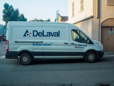 Cremona, İtalya 19 Temmuz 2024 DeLaval markasını taşıyan beyaz bir minibüs şehir caddesine park etmiş, mal ve hizmetlerin taşınması ve teslimatı öneriyor.