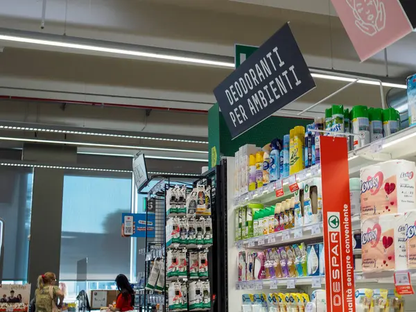 Cremona, İtalya 19 Temmuz 2024 Müşteriler deodorant, oda spreyi ve diğer ev hijyen ürünleriyle dolu bir süpermarket koridoruna bakıyorlar.