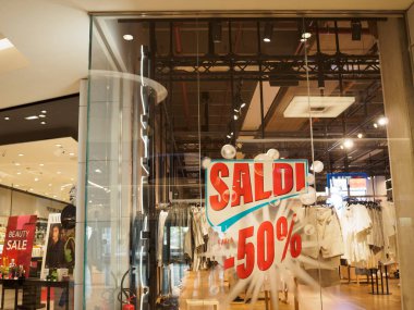 Cremona, İtalya 19 Temmuz 2024 giysi mağazası vitrininde mankenler, kadın ve erkekler için yaz modası giyiyorlar ve yüzde 50 indirimli reklam yapıyorlar.