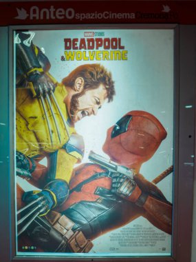 Cremona, İtalya 29 Temmuz 2024 Wolverine ve Deadpool 'un yoğun savaş, kıskaç ve silahların çarpıştığı heyecanlı film posteri dramatik bir sahnede
