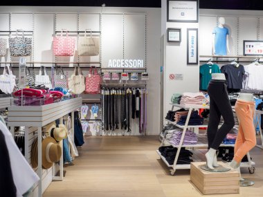 Cremona, İtalya. 29 Temmuz 2024. Parlak ışıklı giyim mağazası. Mankenler en son yaz moda eğilimlerini sergiliyor.