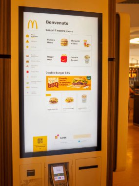 Cremona, İtalya 29 Temmuz 2024 Dijital self servis menü, fiyat ve ödeme seçeneklerini gösteren bir fast food restoranında büfe siparişi veriyor