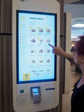 Cremona, İtalya 29 Temmuz 2024 Müşteri bir fast food restoranında dijital self servis büfesi kullanıyor.