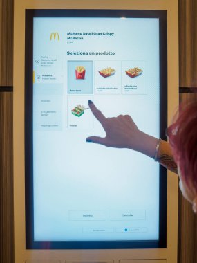 Cremona, İtalya 29 Temmuz 2024 Bir müşteri fast food restoranında yemek sipariş etmek için dijital self servis terminalini kullanıyor