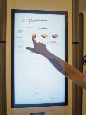 Cremona, İtalya 29 Temmuz 2024 Bir müşteri fast food restoranından yemek sipariş etmek için dijital self servis interaktif büfesi kullanıyor